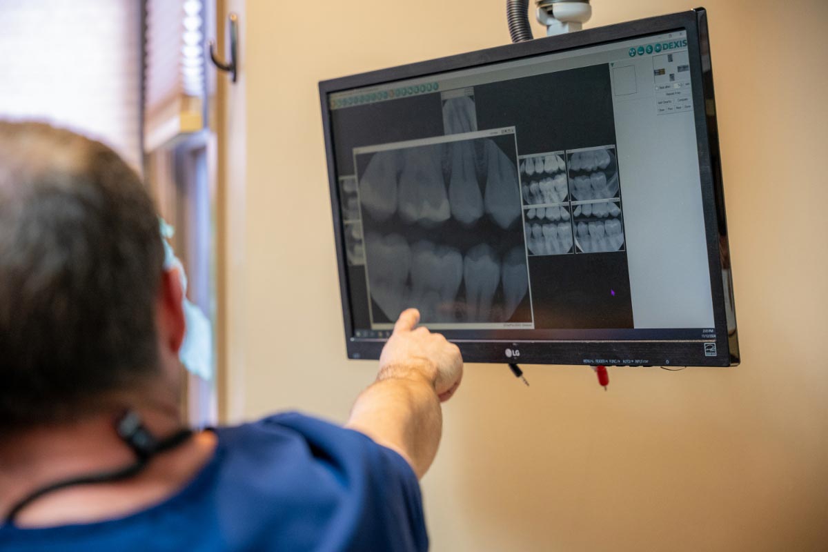 Dr. Pedego showing a dental implant x-ray to a patient
